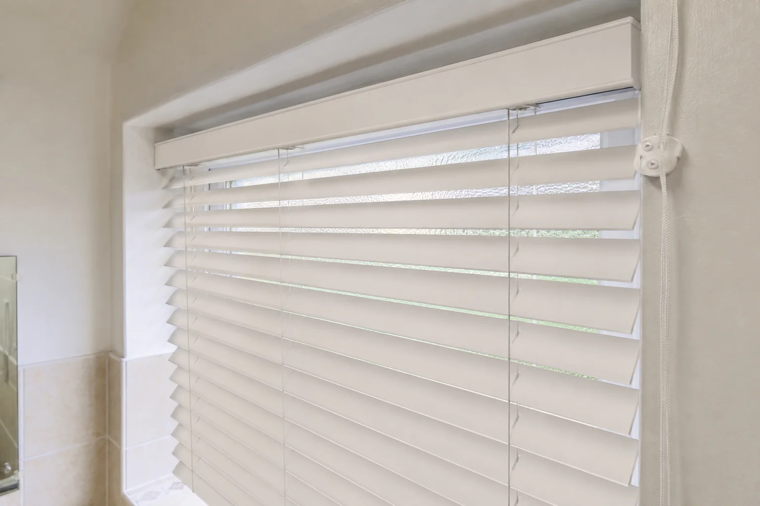 Half-open white Venetian blind in bathroom