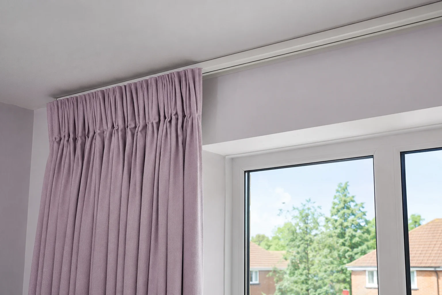 Lilac pencil-pleat curtains by the bedroom window