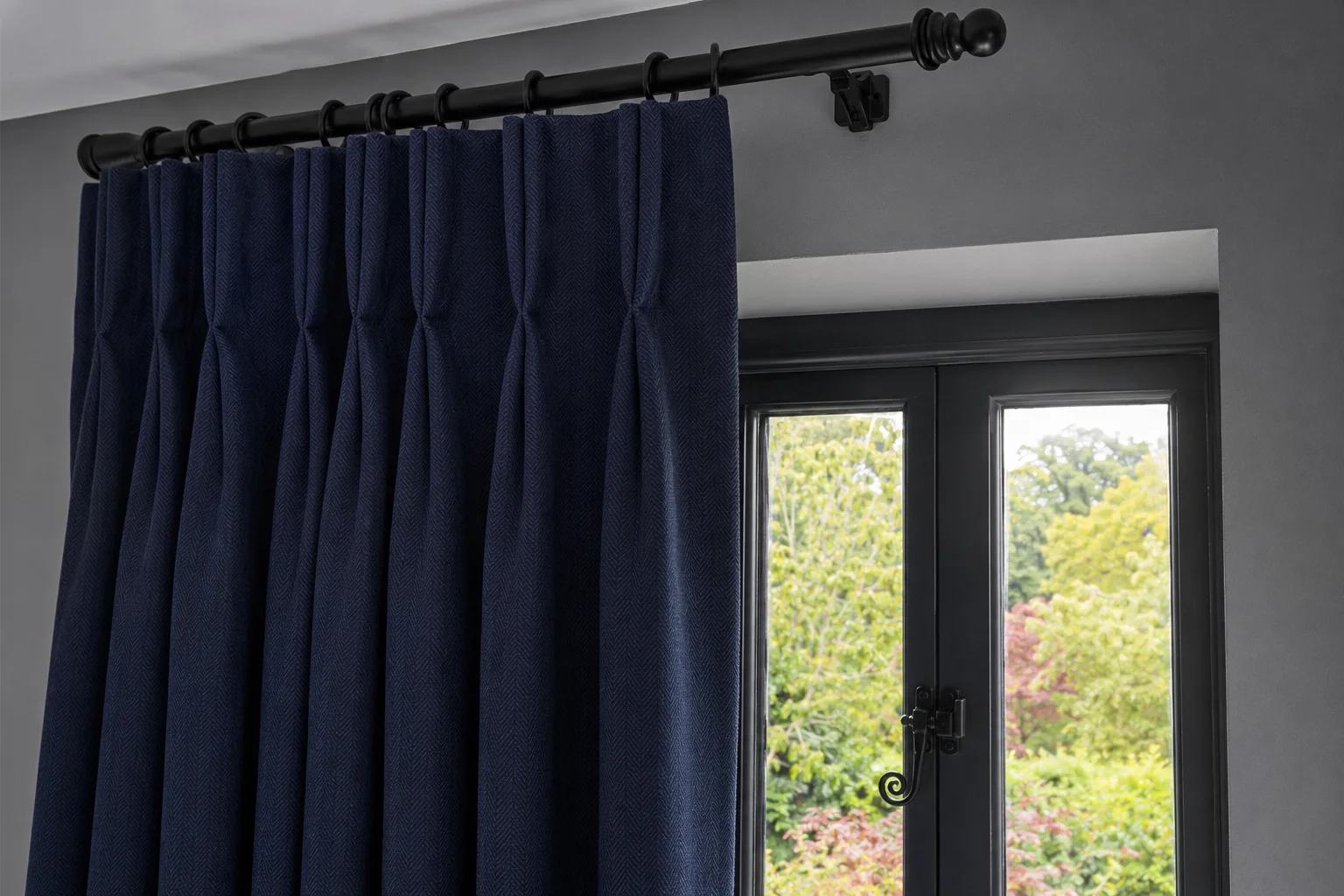 Navy double-pleat curtains at a library window